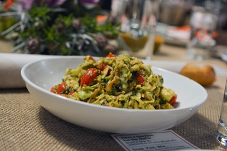 Pasta dish with tomatoes and pesto in a white bowl
