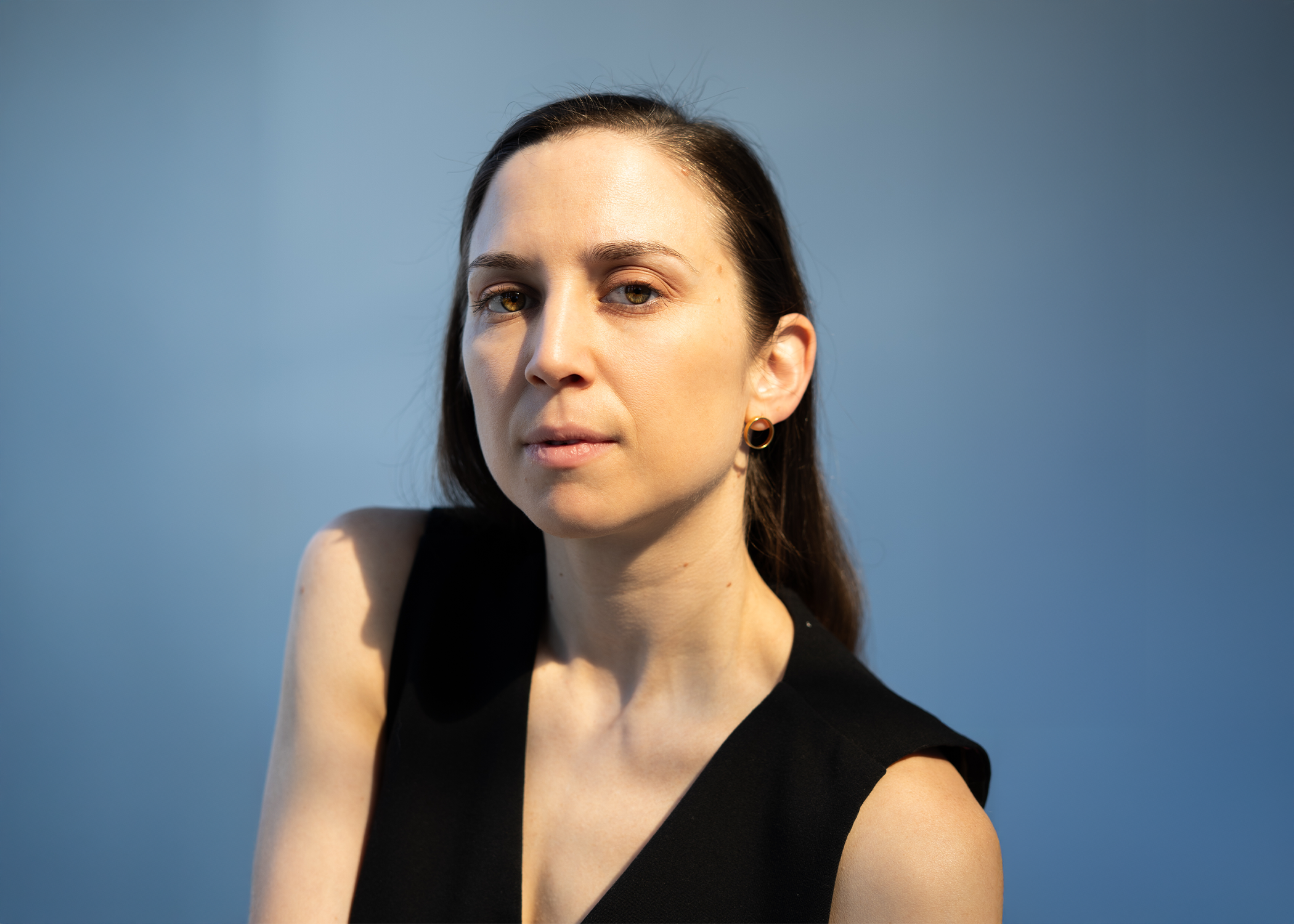 Nicole von Arx headshot. Wearing black and striking an angular pose with their shoulders.