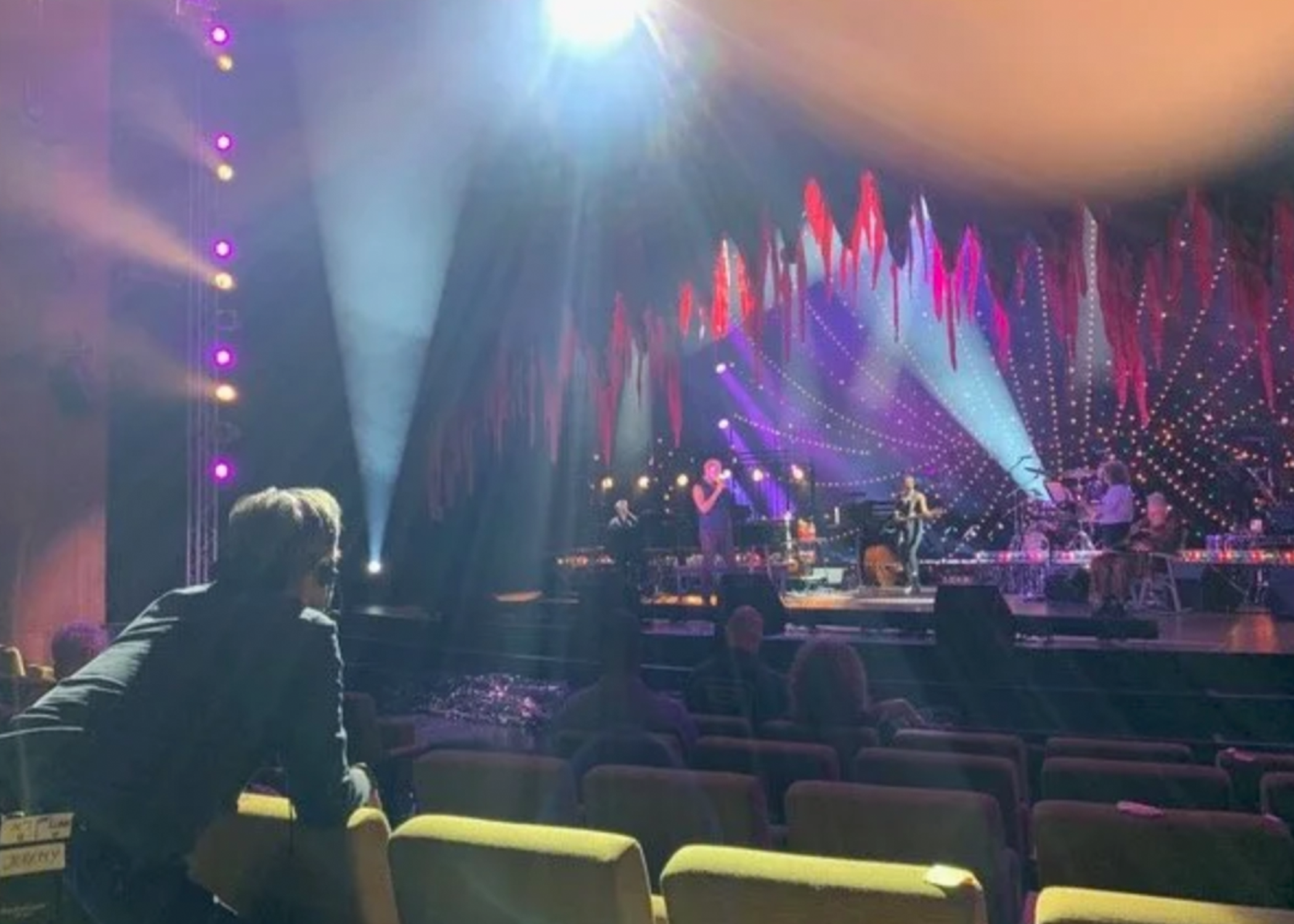 Person is looking at a stage lit with interesting colors.