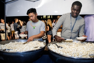 Two students scooping popcorn from large bowls at Bulldog Bash 2018
