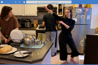 Woman dances through a kitchen at home while family members prepare a meal