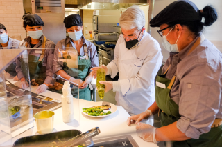 Yale President Peter Salovey helps a team of Hospitality staff prepare lunch in Commons