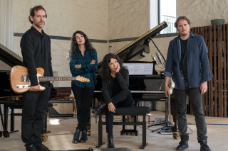 Bryce Dessner (left) holding a guitar, Katia & Marielle Lebeque (center) at a grand piano, with David Chalmin (right) holding a guitar
