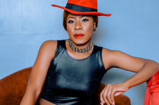 Lady Jaydee in a Red hat and black leather crop top.