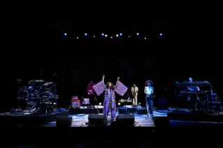 Corinne Bailey Rae on stage in sequined purple kimono.