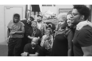 Black and white image of a group of people with their attention focused.