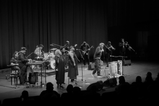 Black and white photo of a group performance on stage.