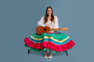 In colorful skirt with guitar.