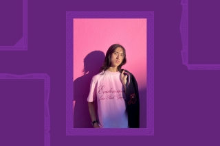WilliamZhang in a pink t-shirt on a pink wall with shadow, holding a jacket.