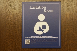 Signage for lactation room on wooden door. 
