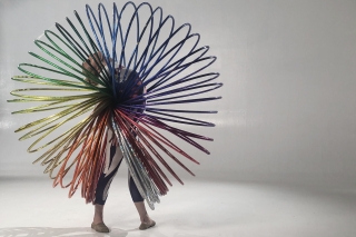Acrobatic move with giant rainbow slinky.