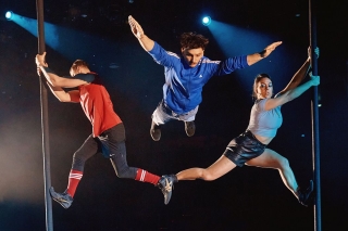 Three people performing acrobatic feats.