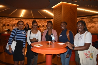 A group of smiling students enjoy each company in The Well.