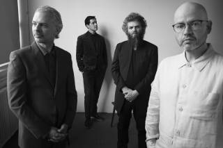 Four folks in black and white, all posing.