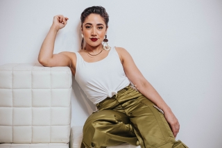 Casual leaning pose on a white chair. White tank top.