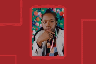 Man with hand on chin in front of floral background.