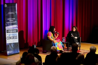 Two people on stage in front of audience. 