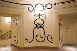 Black applique of braids mixes with classic architectural elements.
