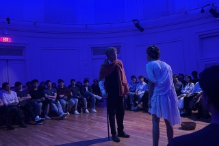Two actors surrounded by audience. 
