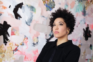 Julia Bullock in front of colorful abstraction. Pink, black, white, blue.