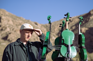 Artist outdoors with green painted instruments.