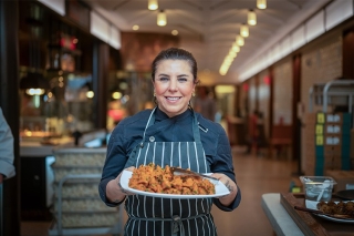 Chef holding a plate of food.