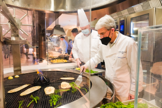 Yale President Peter Salovey assist Chef Dave Kuzma grilling vegetables in the Commons servery