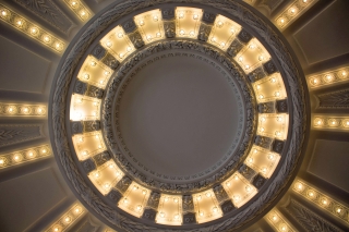 The rotunda's ceiling with lights circling its center and radiating outward.