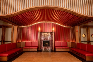 An alcove with red booth seats and wood and red tiled walls.
