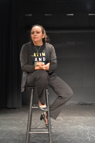 Woman sitting on stool on stage at 2019 LatinXcellence Showcase