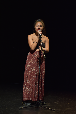 Student speaking or singing into microphone at 2019 LatinXcellence Showcase