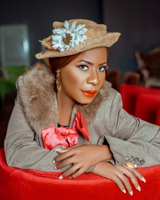 Lady Jaydee in a straw floral hat with a fur collar on her jacket.