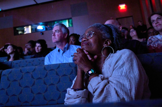 Audience in the blue light of the film. 