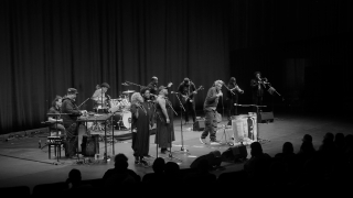 Black and white photo of a group performance on stage.
