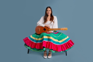 In colorful skirt with guitar.