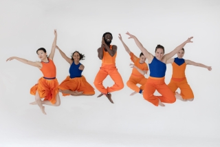 Dancers in orange jumping