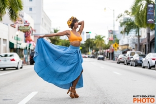 Dancer holding blue skirt in beautiful pose.
