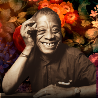 James Baldwin smiles, hand on head, in front of floral backdrop.