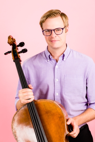 Pink background, instrument and lavender shirt.