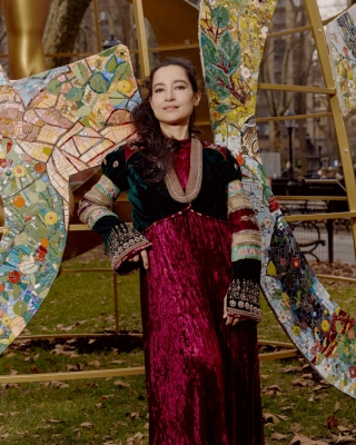 Artist in red, with textural arwork around her.