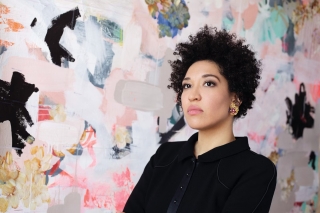 Julia Bullock in front of colorful abstraction. Pink, black, white, blue.