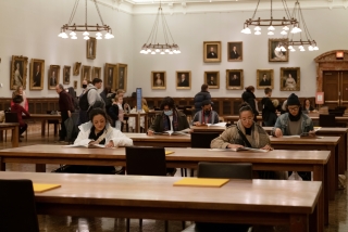 People sit at desks and read.
