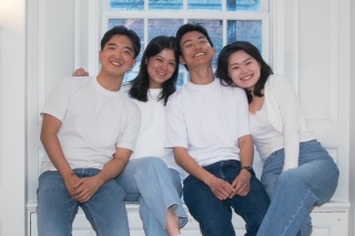 Four people sitting by the windows, wearing white shirts and jeans
